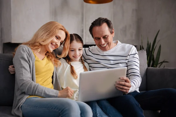 Positieve familie thuis met behulp van elektronische gadget — Stockfoto