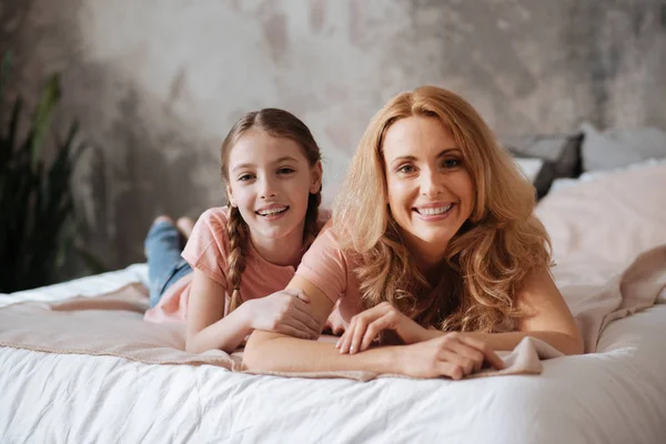 Mãe alegre e filha pequena relaxando em casa — Fotografia de Stock