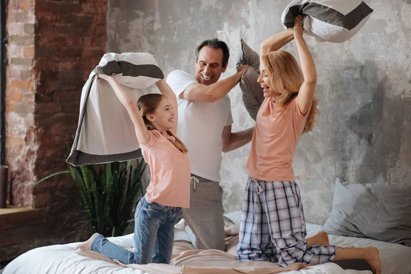 Amused family enjoying pillow fight at home — Stock Photo, Image