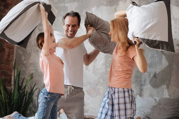 Lively family enjoying pillow fight at home — Stock Photo, Image