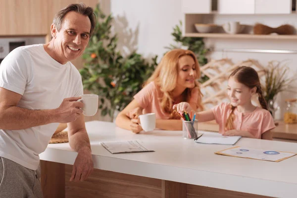 Heureux mature l'homme appréciant matin routine avec famille à l'intérieur — Photo