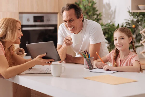 Alegre madura madre usando gadget con la familia en casa — Foto de Stock