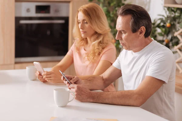 Pareja madura obsesionada mostrando adicción a los gadgets en casa — Foto de Stock