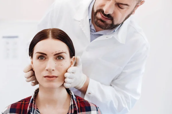 Handsome bearded doctor standing behind his patient — Stock Photo, Image