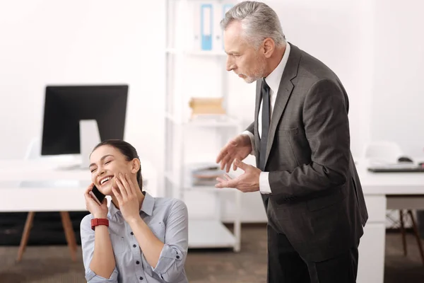Positive delighted office worker speaking with her friend