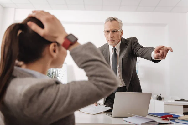 Enojado jefe de pie frente a su secretaria — Foto de Stock