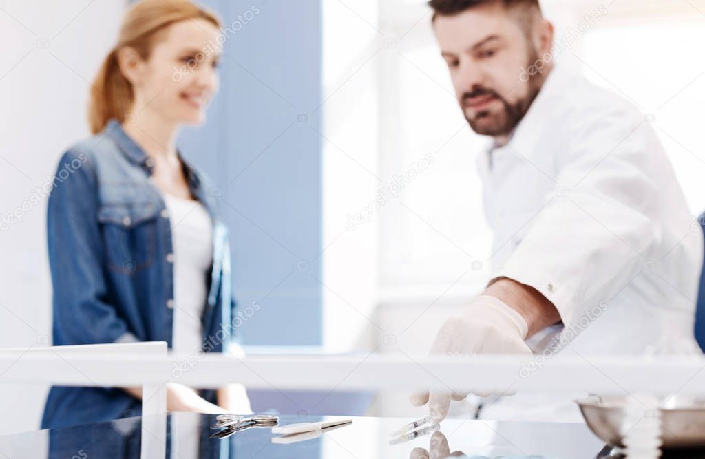 Nice male doctor taking a syringe