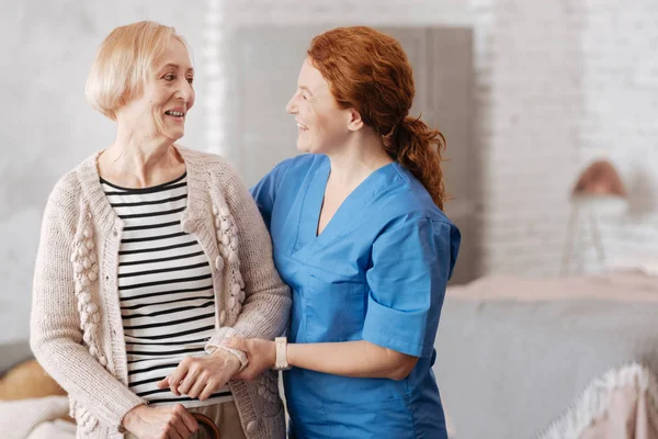 Дружелюбная счастливая медсестра, наслаждающаяся беседой со своим пациентом — стоковое фото