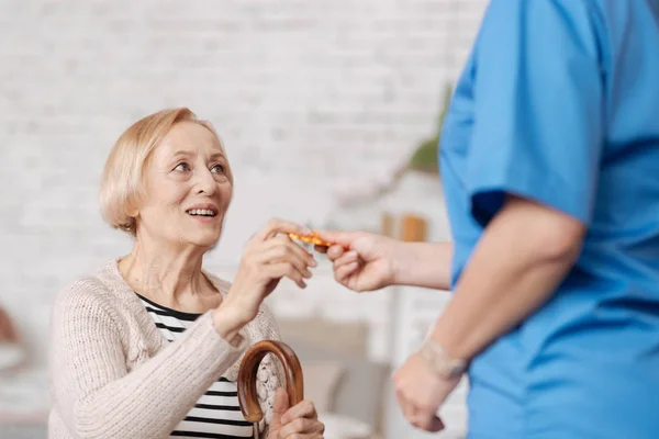 Encantadora doctora entrenada entregando a su paciente las pastillas — Foto de Stock