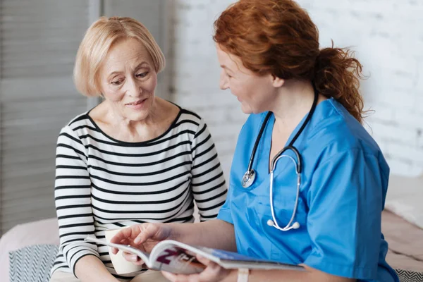 Amable médico animado discutiendo algo con su paciente — Foto de Stock