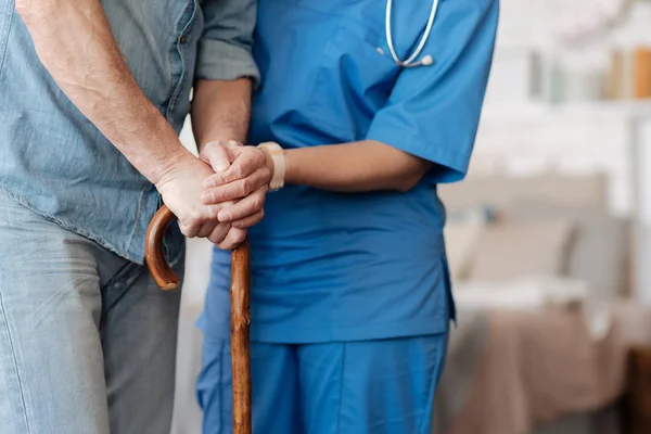 Soort opgeleide verpleegkundige helpen zwakke gentleman wandelen — Stockfoto