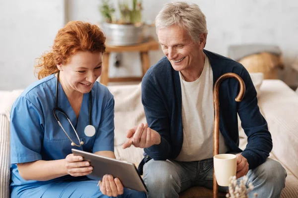 Médico sabio entrenado entreteniendo a su paciente — Foto de Stock