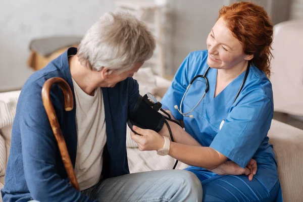 Médico experiente e atencioso empregando tonômetro para medições — Fotografia de Stock