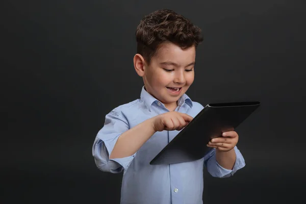 Clever little gentleman typing on his tablet — Stock Photo, Image