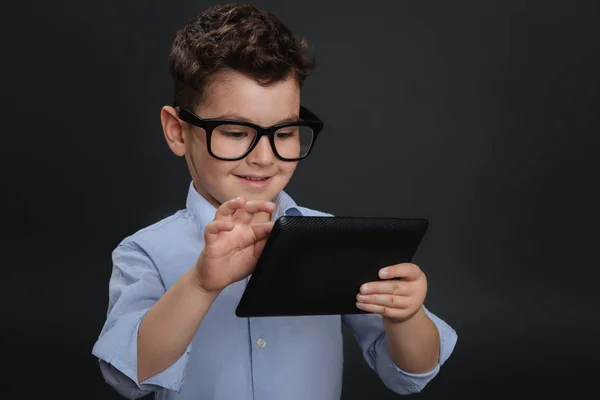 Savvy little student reading on his tablet — Stock Photo, Image