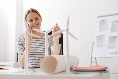 Akıllı telefonda konuşurken neşeli kadın mühendis