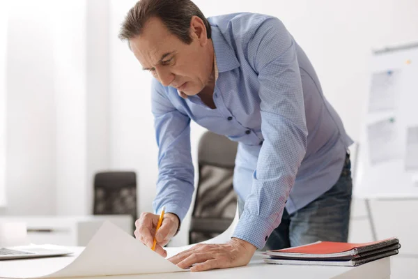 Professional geconcentreerd ingenieur het aanbrengen van wijzigingen in de blauwdruk — Stockfoto