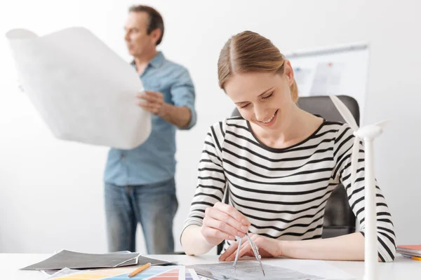 Positieve professionele vrouw ingenieur tekenen met kompassen — Stockfoto