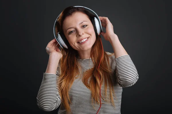 Charmed leende flicka Lyssna på musik — Stockfoto