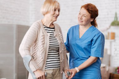 hevesli Bayan koltuk değneği kullanarak