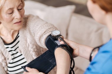 Bir tonometer giyen yapan olgun Bayan
