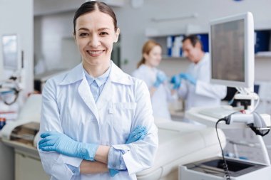 Kameraya gülümseyen pozitif memnun kadın laboratuar asistanı