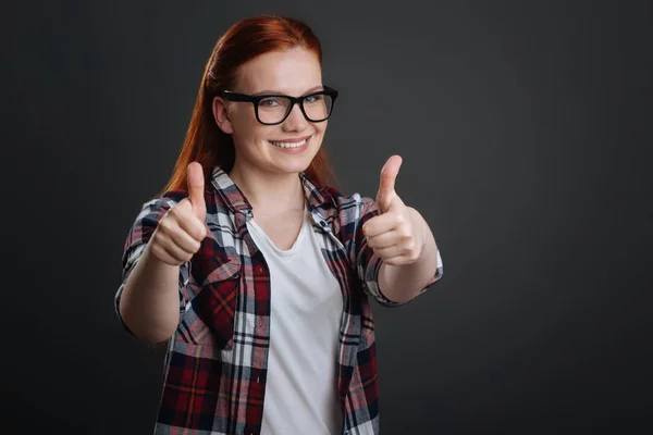 Chica sosteniendo sus pulgares hacia arriba — Foto de Stock