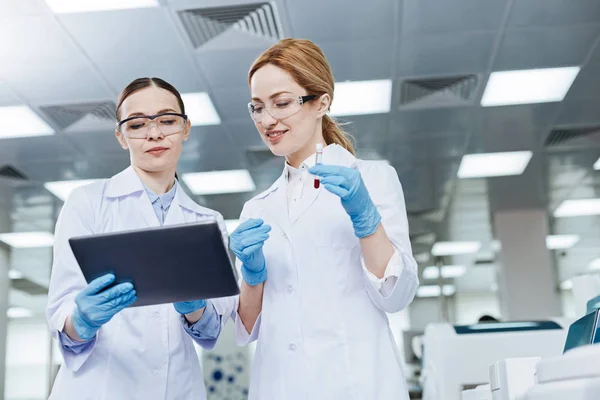 Asistentes de laboratorio encantados positivos mirando hacia abajo — Foto de Stock