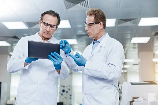 Scientist listening attentively to his assistant — Stock Photo, Image