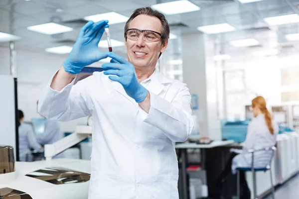 Medical worker while looking at test tube — Stock Photo, Image