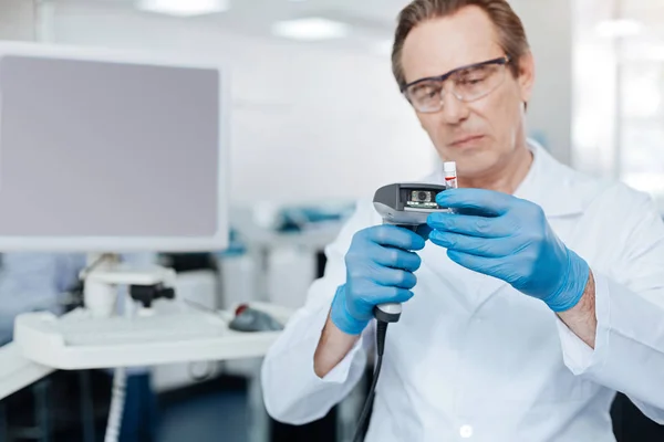 Assistant looking attentively at test glass — Stock Photo, Image