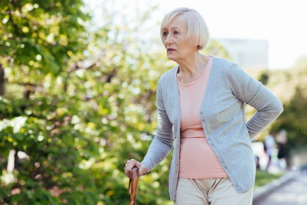 Aged woman walking in the park — Stock Photo, Image