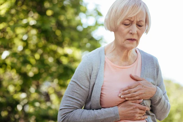 Mujer de edad bien parecido tener un ataque al corazón al aire libre — Foto de Stock