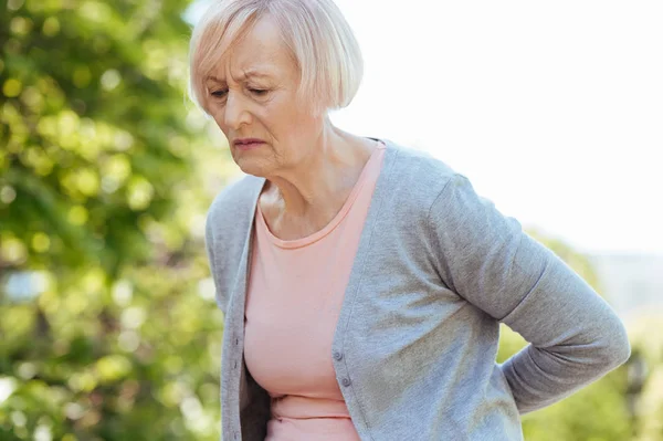 Frustrated pensioner suffering from pain in the back outdoors — Stock Photo, Image