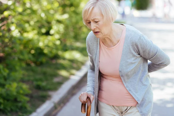 Weak pensioner suffering from backache on the street — Stock Photo, Image