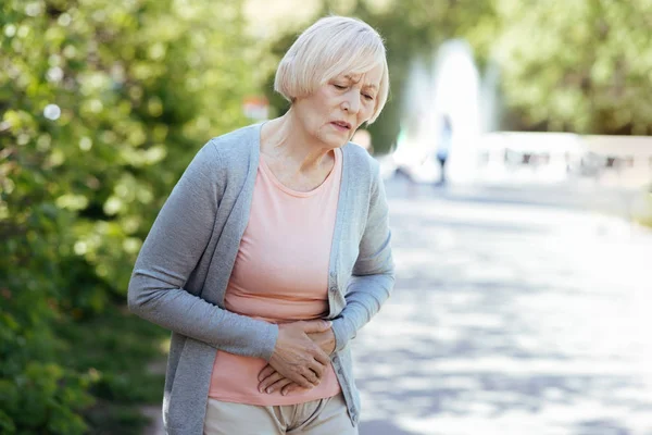 Pensionato depresso con mal di stomaco all'aperto — Foto Stock