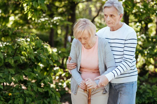 Пациент пенсионер поддерживает старшую жену на открытом воздухе — стоковое фото