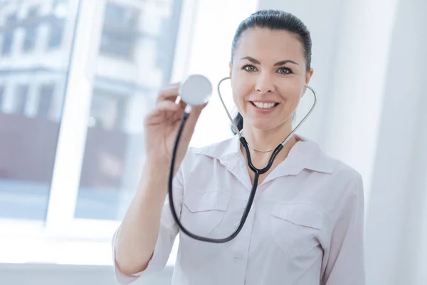 Uśmiechający się lekarz, wykazując profesjonalne urządzenie w klinice — Zdjęcie stockowe