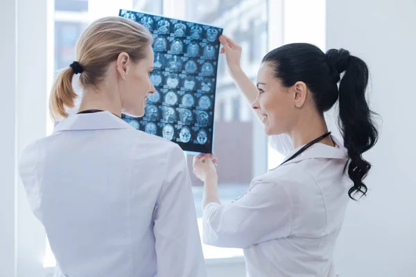 Friendly sjuksköterskor diskutera ct scan resultat på roentgen skåpet — Stockfoto