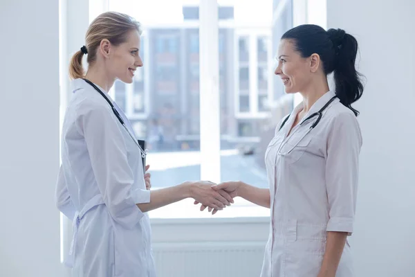 Profesionales sonrientes conociéndose en la clínica — Foto de Stock