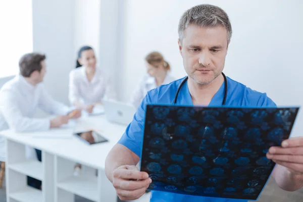 Neurólogo serio examinando foto de escaneo mrt en el laboratorio — Foto de Stock