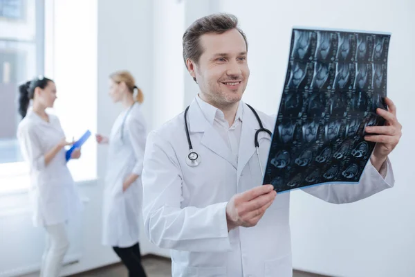 Опытный хирург осматривает рентгеновские снимки в медицинской лаборатории — стоковое фото