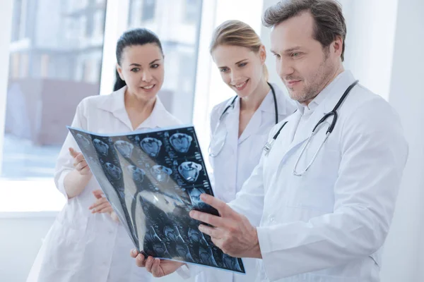 Оптимістичні рентгенографи обговорюють фото рентгенівського променя в клініці — стокове фото