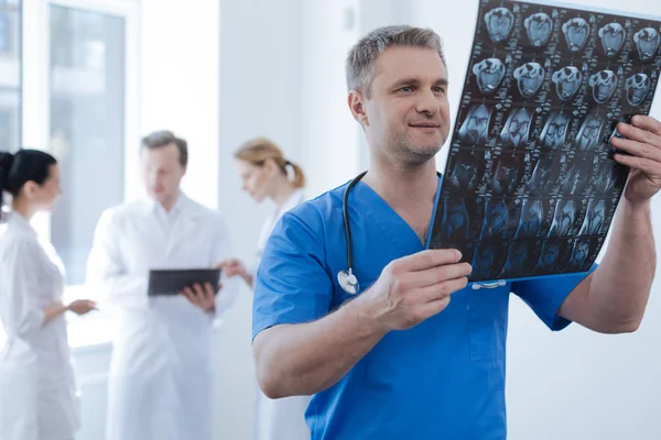 Oncologista atencioso analisando foto tomografia na clínica — Fotografia de Stock