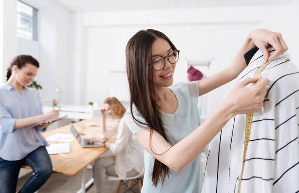 Tailleur prenant les mesures d'un cardigan rayé — Photo