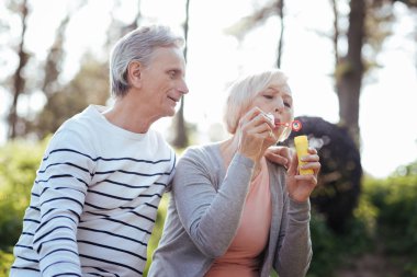 Neşeli emekliler sabun köpüğü parkta yapma