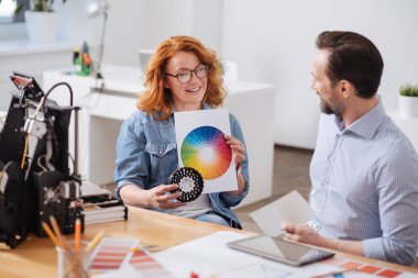 Bir renk paleti tutan memnun güzel kadın