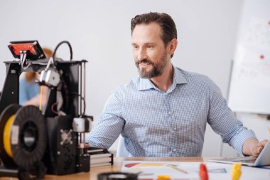 Bilgisayarda çalışan neşeli pozitif adam