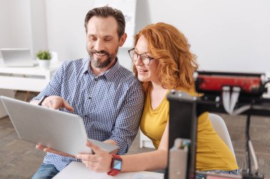 Dizüstü bilgisayar ekranına bakarak olumlu memnun tasarımcıları