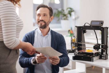 3d yazıcının önünde oturan neşeli yakışıklı adam